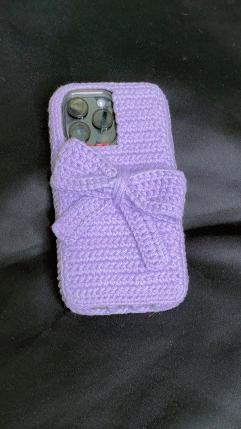 Purple phone case with a bow on a black surface