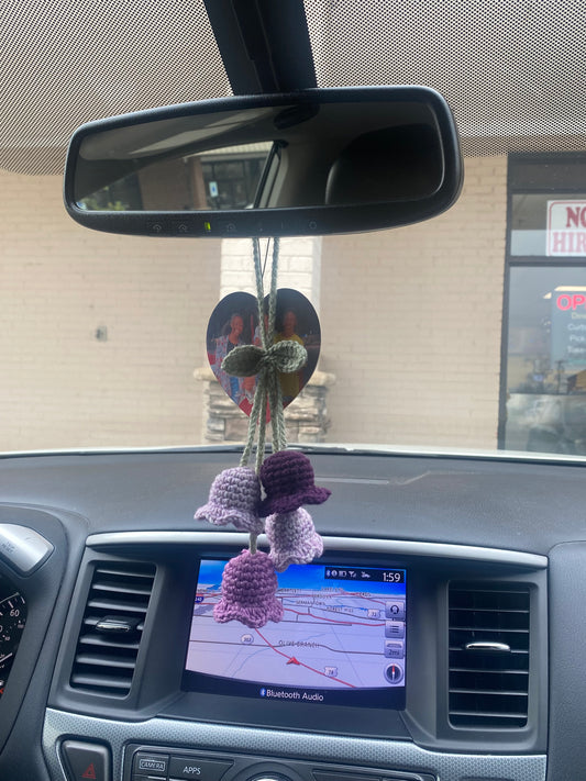 Car interior with a decorative purple flower on the rearview mirror